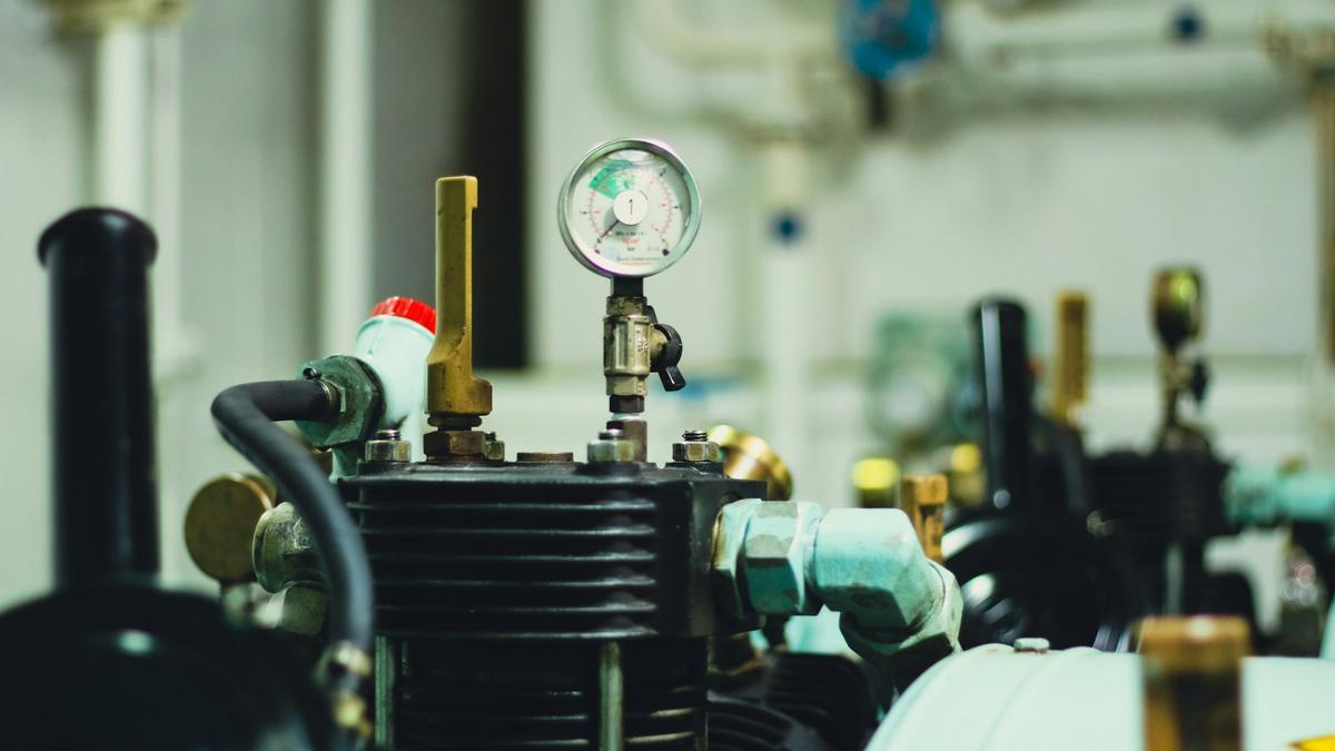 Close-up of engine room machinery with a pressure gauge