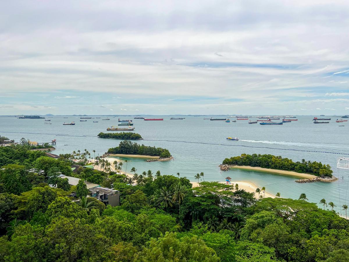 View from Sentosa over small islands and beaches towards ships at anchor in the Singapore Strait