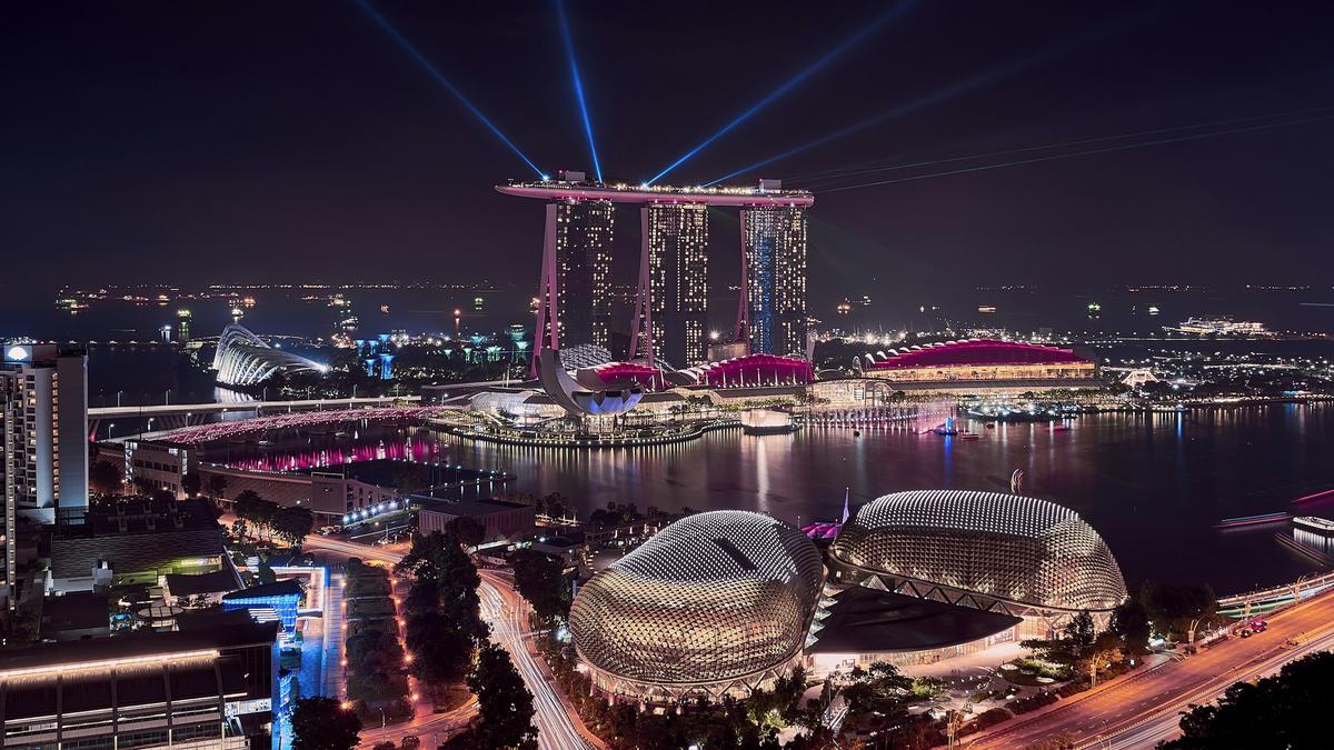 Marina Bay, Singapore, at night with light beams over the bay